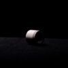 un tube blanc posé sur une surface noire